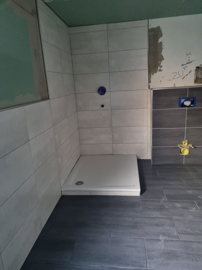 Sanierung eines Bads durch neue Verfliesung und Sanitärobjekte