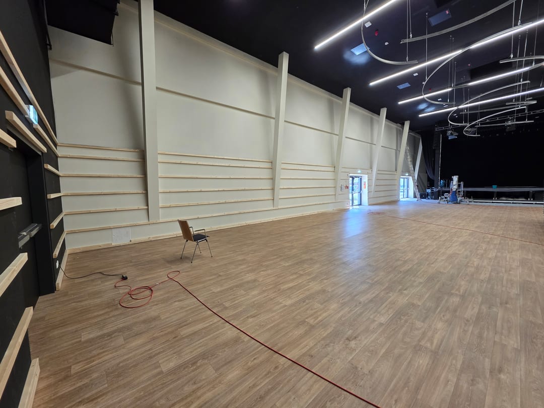 Halle im Deichherz mit Unterkonstruktion aus Holzlatten an der hellen Wand vor Beginn der Verschalung