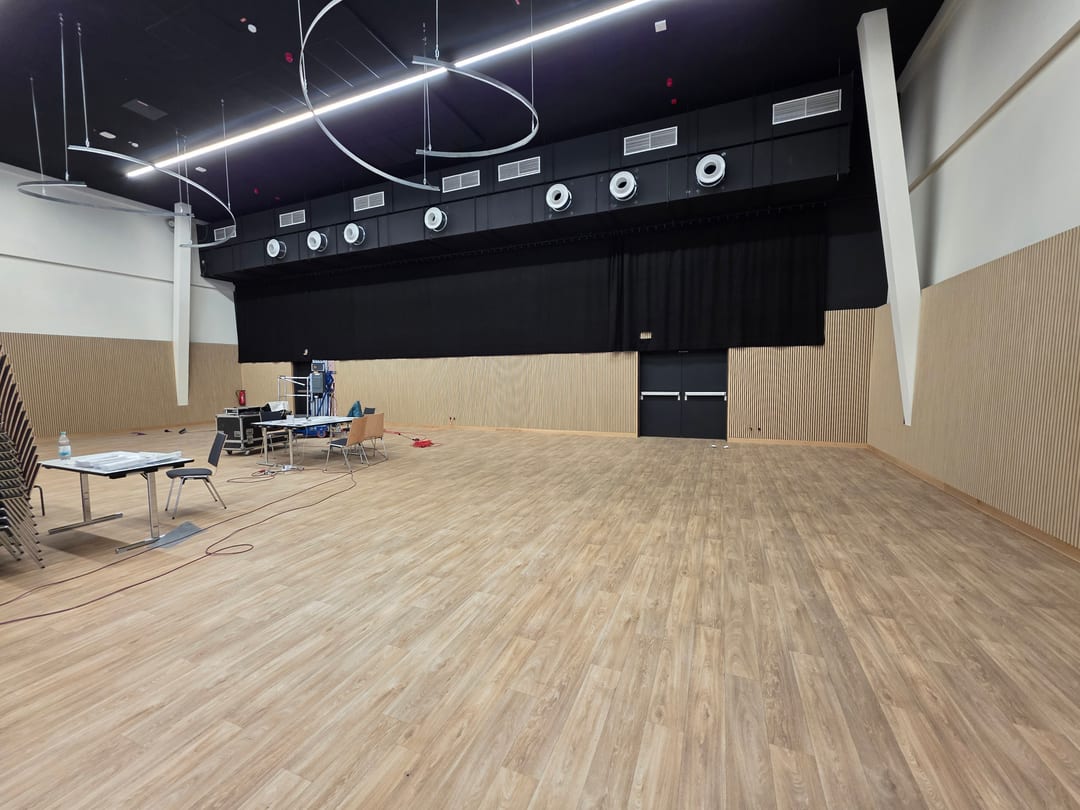 Fertige Halle im Deichherz mit umlaufender Akustikverschalung aus Holzpaneelen und Sockelleisten