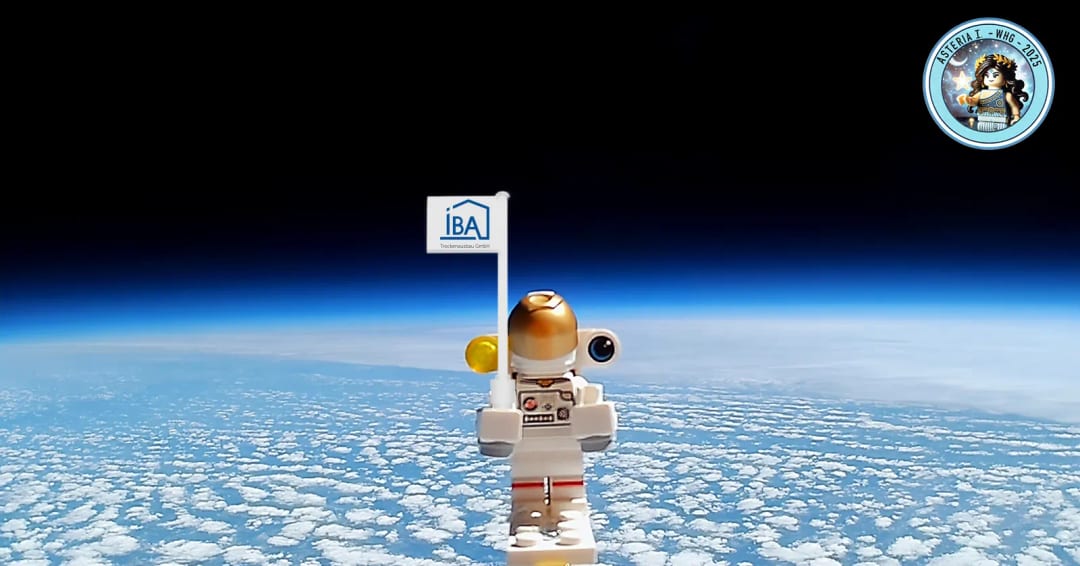 Astronauten-Spielfigur mit IBA-Fahne vor der gekrümmten Erde, aufgenommen aus der Stratosphäre